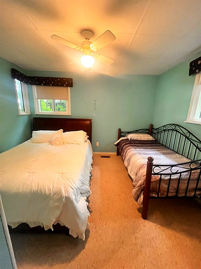 The blue bedroom with a queen bed and an iron double bed
