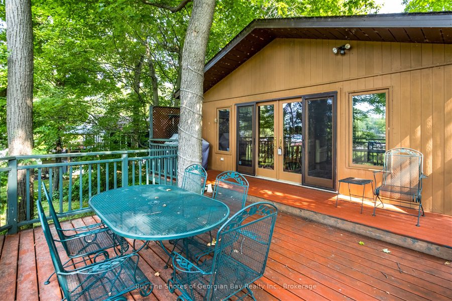 Raised deck with a patio dining set and glass doors into the house