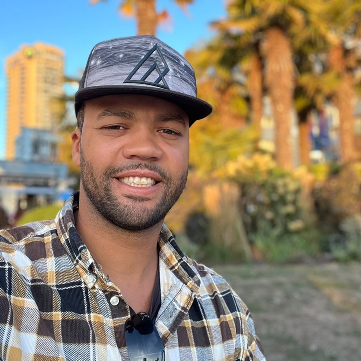 Sheldon Caines, owner and host of Forest Harbour Lake House, smiling in a plaid shirt and cap