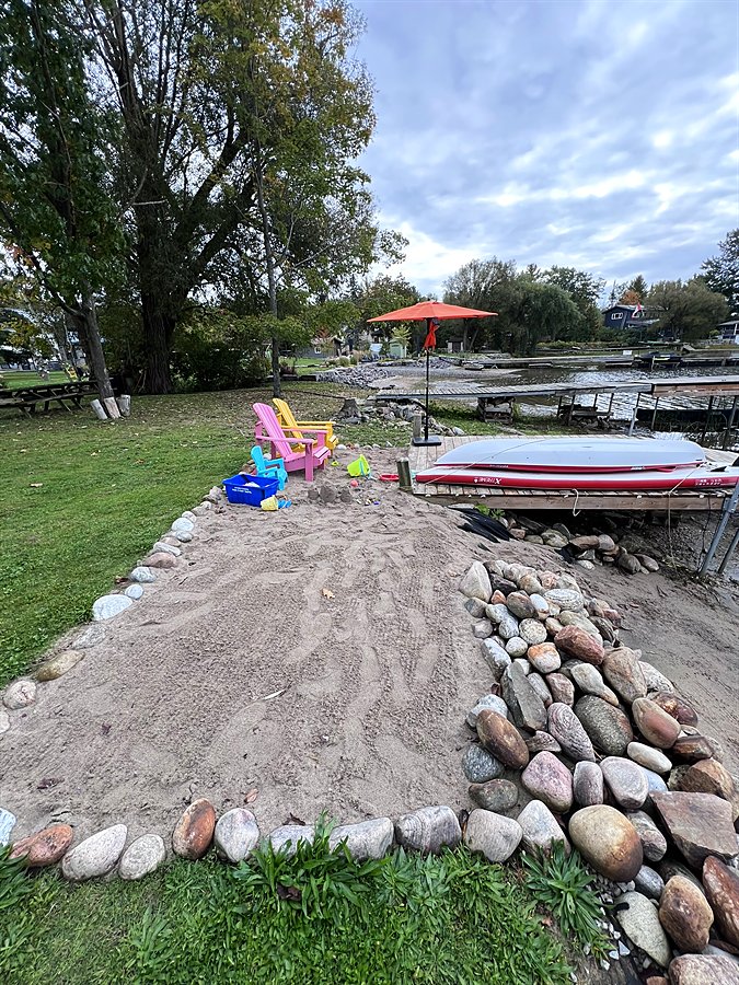 Stone-edged sand beach beside the dock