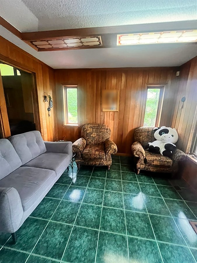 Sunroom lounge with a small loveseat and two single armchairs, with windows all around